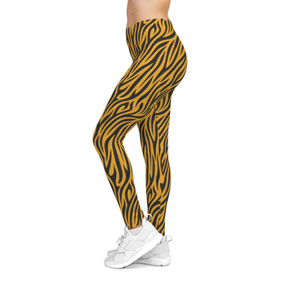 Side view of casual leggings featuring a bold tiger stripe pattern with black wavy stripes on a vibrant orange background. The fabric has a smooth, silky texture.