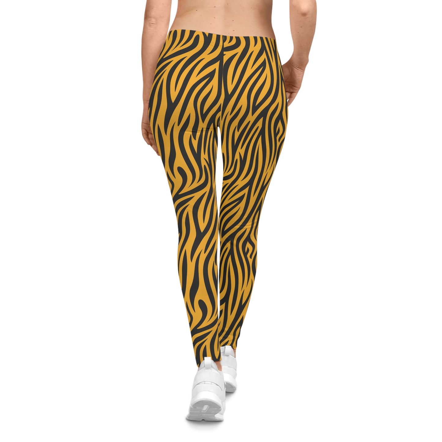 Rear view of casual leggings featuring a bold tiger stripe pattern with black wavy stripes on a vibrant orange background. The fabric has a smooth, silky texture.