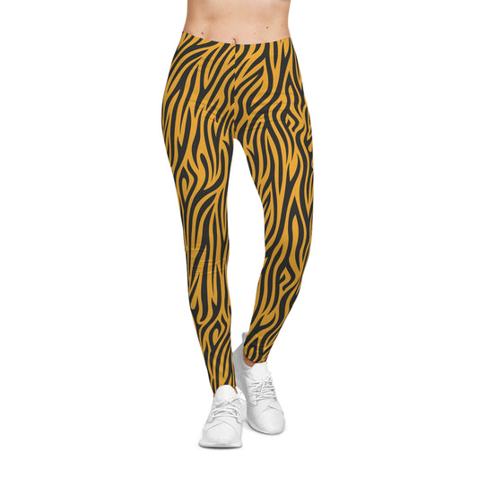 Front view of casual leggings featuring a bold tiger stripe pattern with black wavy stripes on a vibrant orange background. The fabric has a smooth, silky texture.